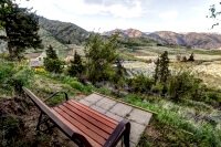 Rocking bench on our hiking trails with views of green orchards and wildflowers